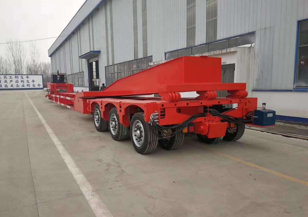 A folding extension beam at rear of a hydraulic multi-axle trailer