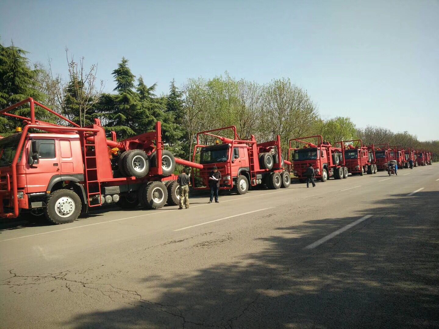 Red color log trailers waiting for delivery