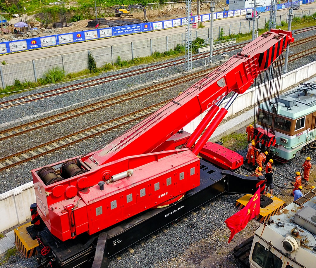 Railway crane lifting an old locomotive